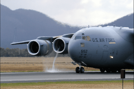 A Boeing C-17 creates a visible vortex while using thrust reversal